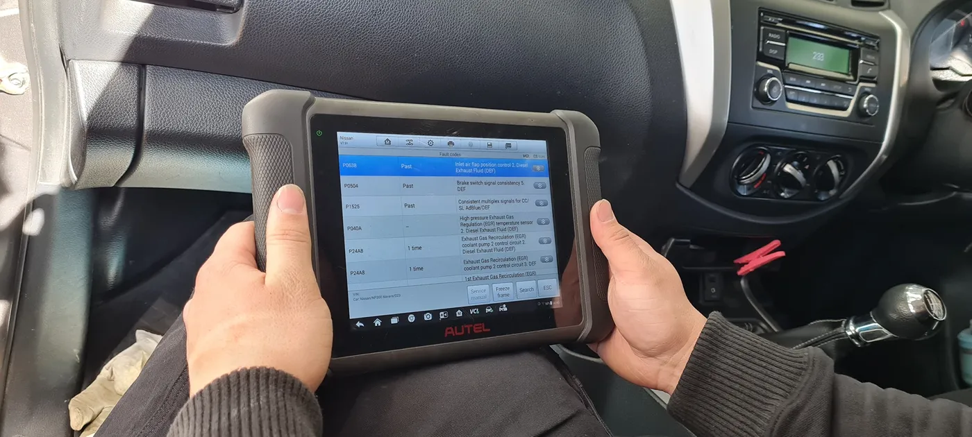 Technician reading live fault codes on an Autel diagnostic scan tool
